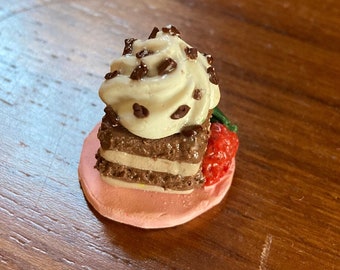 Uma sobremesa de camada de brownie com morango ao lado - comida de exibição para casa de bonecas de argila de polímero