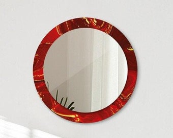 May include: A round mirror with a red frame, hanging on a white wall above a bed with white bedding and wooden headboard.