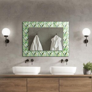 Puede incluir: Un baño moderno con un tocador doble, un espejo grande con un patrón geométrico verde y blanco, y una ducha a ras de suelo con una alcachofa de lluvia.