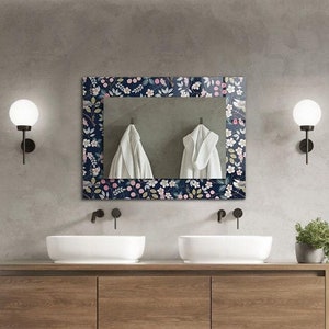 Puede incluir: Un baño moderno con un lavabo doble, un espejo con estampado floral y una ducha a ras de suelo con una alcachofa de lluvia.