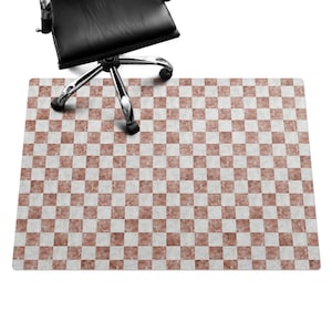 May include: A checkered floor mat with a marble pattern in shades of brown and white. The mat is designed to protect floors from chair wheels.