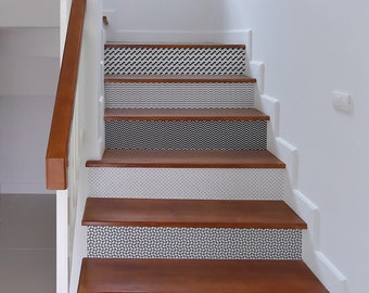 May include: A set of black and white patterned stair treads, with a variety of geometric designs, including waves, zigzags, and dots. The treads are applied to a wooden staircase with a natural wood finish. The text "100% removable by StickersColoray Etsy Shop" is visible at the bottom of the image.
