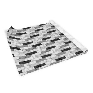May include: A roll of black and white marble patterned contact paper. The paper is rolled up and the end is curled up.