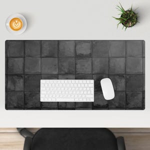 May include: A white keyboard and mouse on a black tiled desk mat. The mat has a textured surface.