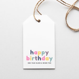 May include: White gift tag with a colorful "happy birthday" message and the text "one year older & wiser too".