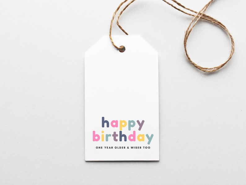 May include: White gift tag with a colorful "happy birthday" message and the text "one year older & wiser too".