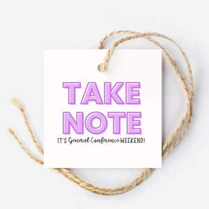 May include: A white gift tag with the text "TAKE NOTE" in purple letters with a white outline. The text "IT'S General Conference WEEKEND!" is written in black below the purple text.