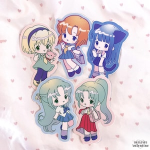 May include: Five die-cut stickers featuring chibi-style anime characters with large eyes and colorful outfits. The characters have various hair colors including blonde, orange, blue, and green, and are depicted in school uniforms or casual attire.
