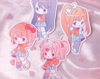 May include: Four die-cut vinyl stickers featuring chibi-style anime characters with large eyes, wearing school uniforms consisting of orange blazers and blue skirts. The characters have distinct hair colors including purple, orange, and pink. Text reads vampire valentine.