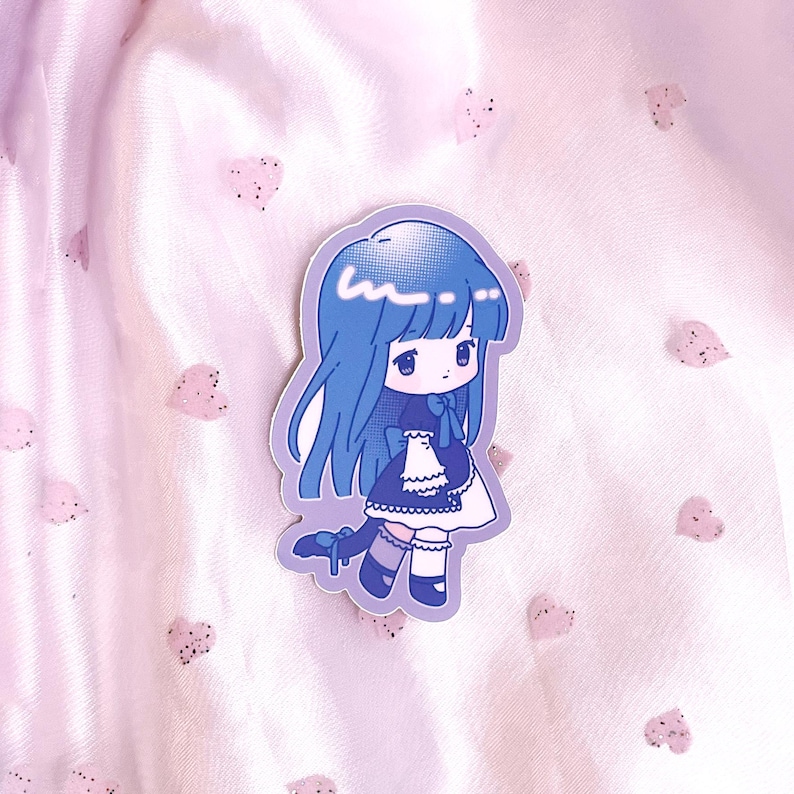 May include: A blue and white sticker featuring a cartoon girl with blue hair wearing a black and white dress and a blue bow. The sticker has a white background with a light blue outline.