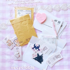 various items related to recycling and reusing, including a recycled mail envelope, a pink heart-shaped sticker, a pen, and some other miscellaneous items.