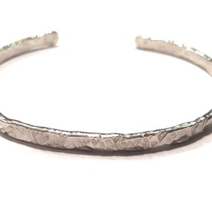 Peut inclure: Un bracelet en argent avec une texture martelée.