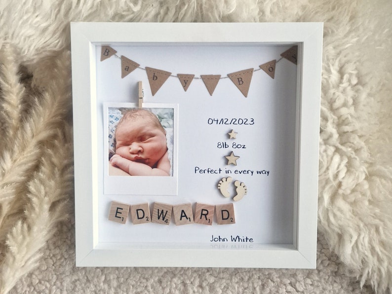 Pode incluir: Uma moldura branca com uma foto de beb&ecirc;, uma faixa que diz "Baby", blocos de madeira que soletram "Edward", uma data, um peso e o texto "Perfeito em todos os sentidos".