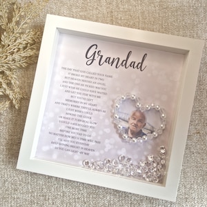 May include: A white framed picture with a poem about a grandparent. The poem is surrounded by a heart made of white beads and a photo of an older man is inside the heart. The background of the frame is a light purple with a sparkle effect.