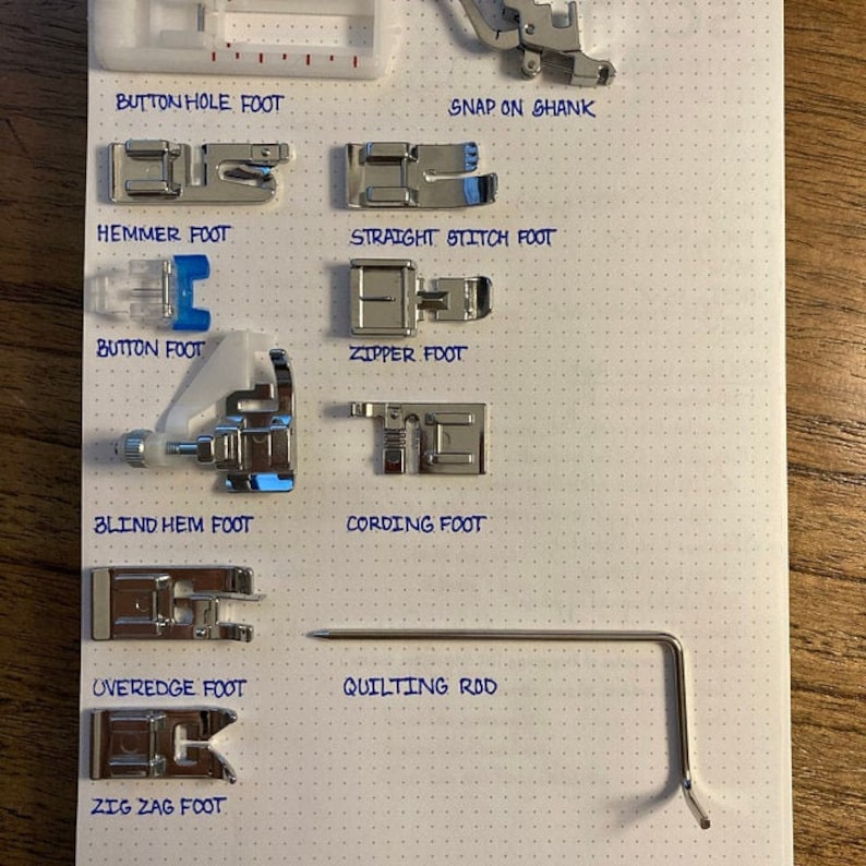 May include: A white sheet of paper with a grid pattern, labeled with the names of different sewing machine feet and a quilting rod. The feet are arranged in rows and include a buttonhole foot, a hemmer foot, a button foot, a blind hem foot, an overedge foot, a zig zag foot, a straight stitch foot, a zipper foot, a cording foot, and a snap-on shank.