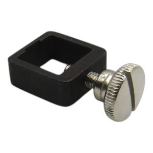 May include: A black metal clamp with a silver thumbscrew. The clamp has a square opening and is designed to hold objects securely.