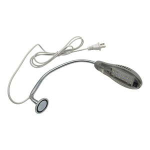 May include: A silver flexible gooseneck LED desk lamp with a magnetic base and a white power cord. The lamp has a clear plastic housing with multiple white LED lights.