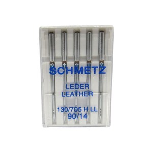 May include: A pack of five silver sewing needles in a clear plastic case. The needles are labeled "SCHMETZ LEDER LEATHER 130/705 H LL 90/14".