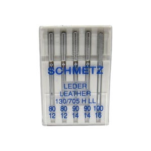 May include: A pack of five silver sewing needles for leather, labeled "SCHMETZ LEDER LEATHER 130/705 H LL 80 80 90 90 100 12 12 14 14 16".