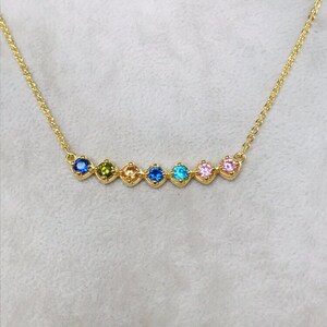 Puede incluir: Un collar de cadena de oro con una fila de siete piedras preciosas de colores. Las piedras preciosas est&aacute;n engastadas en oro y est&aacute;n dispuestas en un patr&oacute;n de arco&iacute;ris.
