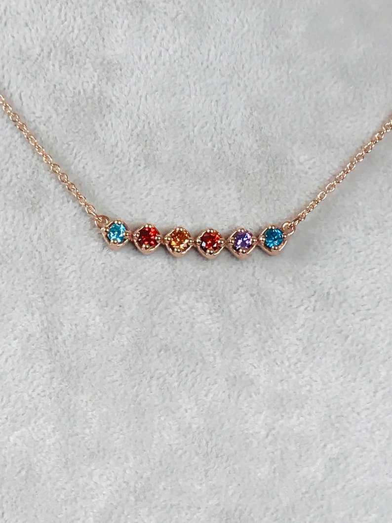 Puede incluir: Un delicado collar de cadena dorada con un arco&iacute;ris de peque&ntilde;as piedras preciosas de forma cuadrada.