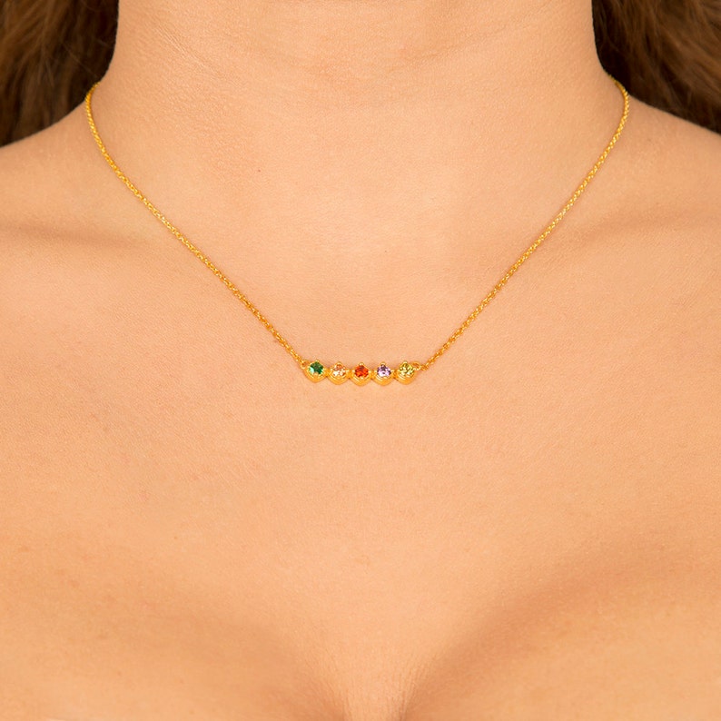 Puede incluir: Un collar de cadena de oro con cinco peque&ntilde;as piedras preciosas en un arco&iacute;ris de colores: verde, amarillo, naranja, rojo y morado.