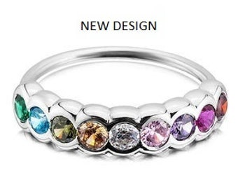 May include: A silver ring with a row of colorful gemstones. The gemstones are set in a bezel setting and are arranged in a rainbow pattern. The ring is a new design.