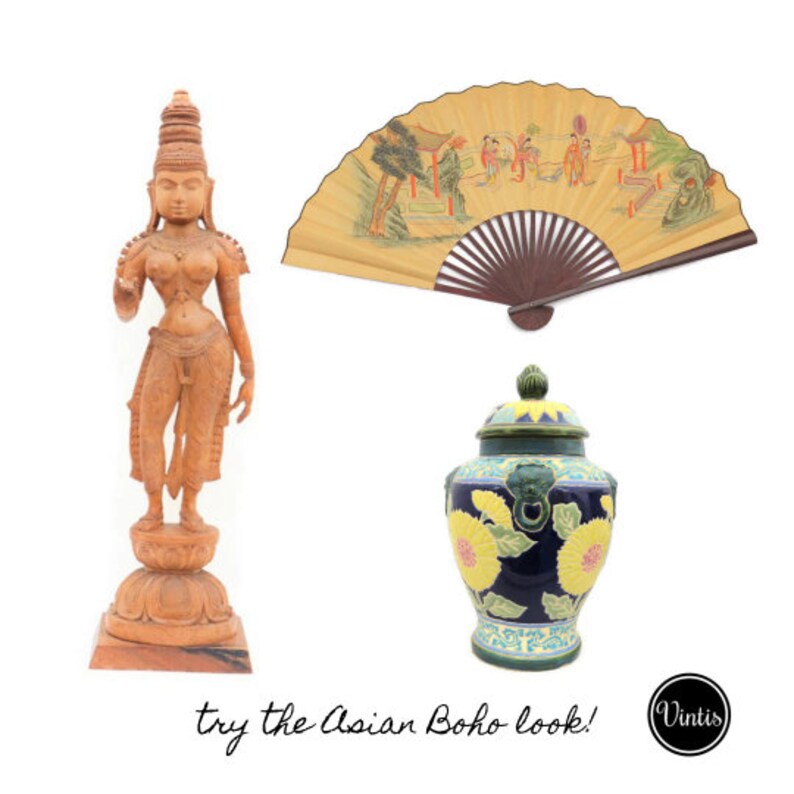 Op de afbeelding: Een houten beeld van een vrouw met een decoratieve waaier en een blauwe en gele keramische pot met bloemenmotieven. De tekst "try the Asian Boho look!" staat onder de afbeelding.