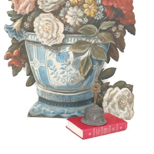 Op de afbeelding: Een blauwe en witte keramische vaas met een bloemenmotief, gevuld met geschilderde bloemen. Een kleine, sierlijke, bronzen bel zit op een rood boek.