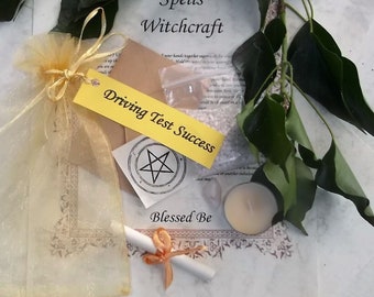 May include: A yellow organza bag filled with a white candle, a small white pouch, a white paper scroll, a yellow tag that says "Driving Test Success", and a white paper with a black pentagram and the text "Blessed Be".