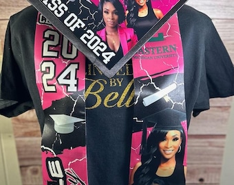 May include: Black t-shirt with a graduation sash and cap. The sash and cap feature the name "Belle Basley", the text "Class of 2024", and images of a woman. The sash also has the text "Eastern Michigan University".