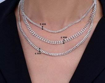 May include: Three silver chain necklaces with cubic zirconia stones. The chains are layered on a model's neck. The chains are 3 mm, 4 mm, and 6 mm wide.
