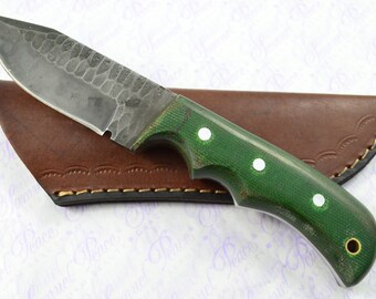 May include: A green handled knife with a hammered steel blade and a brown leather sheath.