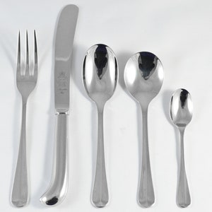 Puede incluir: Un juego de cinco cubiertos plateados, que incluye un tenedor, un cuchillo y tres cucharas de diferentes tamaños.