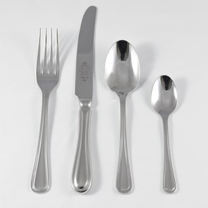 May include: A set of four silver-toned flatware pieces, including a fork, knife, and two spoons. The knife has a decorative design on the handle.