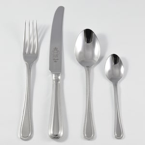Könnte beinhalten: Ein Set aus vier versilberten Besteckteilen, bestehend aus einer Gabel, einem Messer und zwei Löffeln. Die Griffe sind perlenbesetzt und das Messer ist graviert.