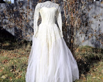 Vestido de novia vintage de encaje color crudo de los años 40: mangas largas atemporales, falda amplia y elegancia nupcial clásica.