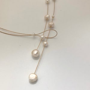 Pearl necklace. Freshwater pearls on a wire of gold. You can vary the lenght by yourself, by fixing one end on a position. Lariat necklace Bild 8