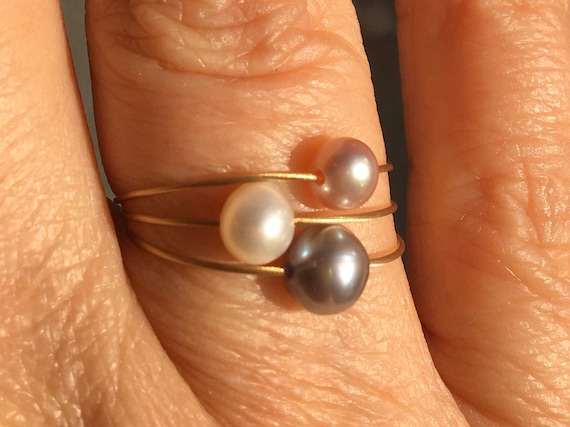 Jewelry Set. 3 pearl rings, white, gray and rose on a wire of gold .