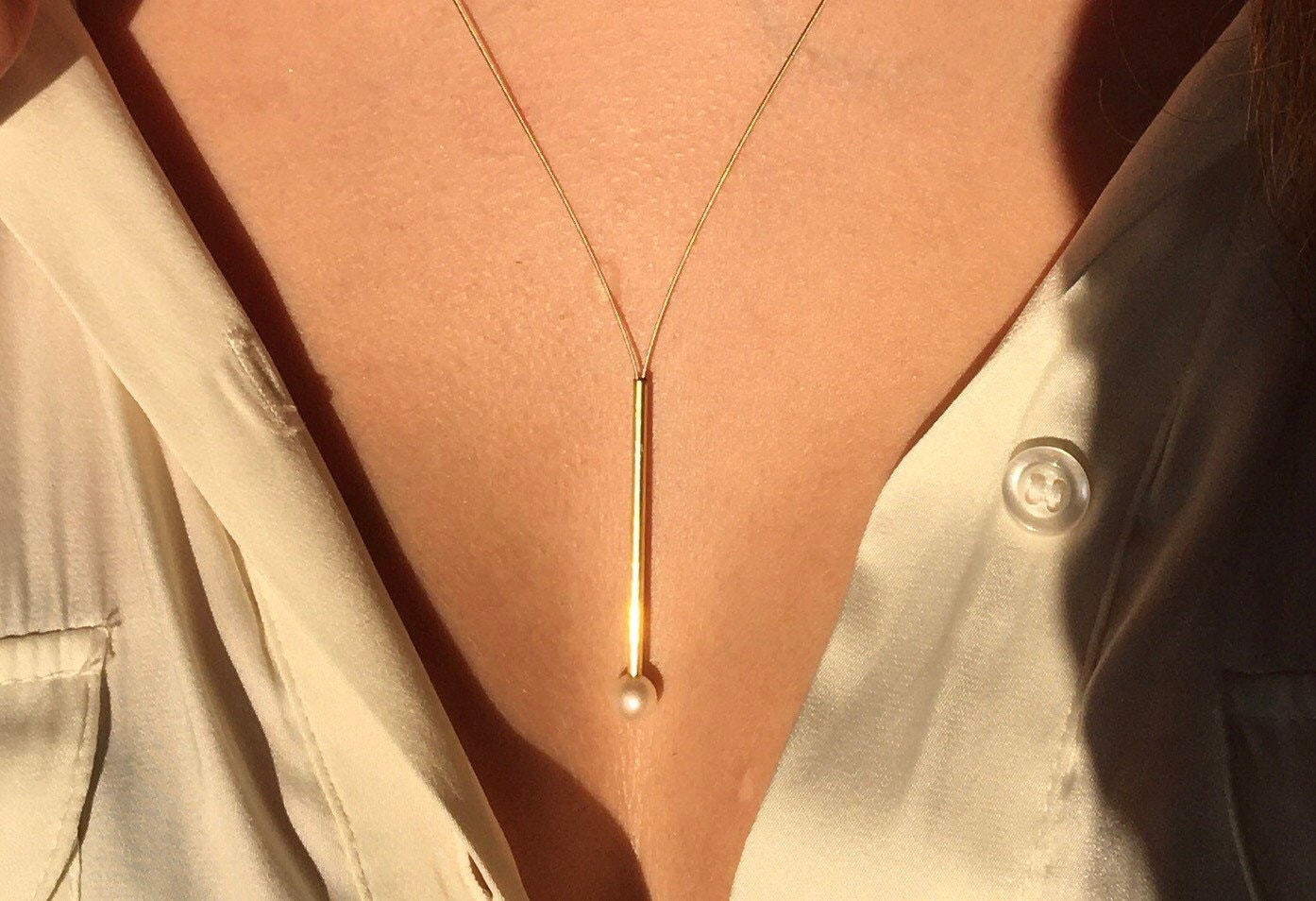 Pearl necklace wearable in three lengths. Gold pipes combined with freshwater pearls