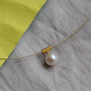 Pearl necklace. Freshwater pearl in a gold square on a wire of gold. You can vary the lenght by yourself.