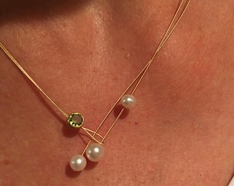 Collana Peridot con Perle. Perle d'acqua dolce con un peridoto incastonato su un filo d'oro.