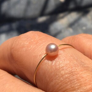 Smyckeset. 3 pärlringar, vita, grå och rosa på en tråd av guld. bild 4