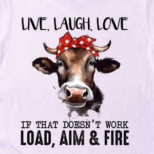 May include: White t-shirt featuring a cow graphic wearing a red polka dot bandana. The shirt has the text "LIVE, LAUGH, LOVE" above the cow image and "IF THAT DOESN'T WORK LOAD, AIM & FIRE" below.
