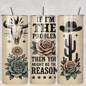 Può includere: Un set di tre bicchieri isolati beige con cannuccia. Ogni bicchiere presenta un design diverso: un teschio di toro, il testo "If I'm the problem then you might be the reason" e un cappello da cowboy con un cactus.