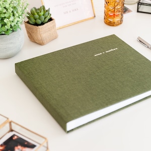 May include: A green linen-covered photo album with white edges and the text "anna & matthew" in gold lettering.