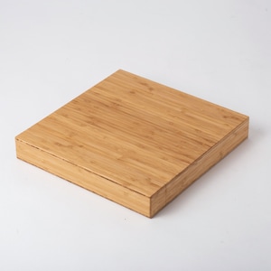 Pode incluir: Uma caixa quadrada de bambu castanho claro com tampa. A caixa &eacute; feita de v&aacute;rias tiras de bambu, criando uma superf&iacute;cie texturizada. A caixa est&aacute; em um fundo branco.