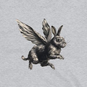 May include: A grey t-shirt with a black and white illustration of a rabbit with wings.