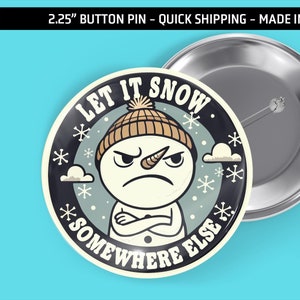 May include: A 2.25-inch button pin with a grumpy snowman illustration. The pin features the text "LET IT SNOW * SOMEWHERE ELSE *" in a circular design with snowflakes and clouds. The pin is made in the USA.