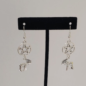 May include: Silver dangle earrings with a pentacle charm and a moose charm.